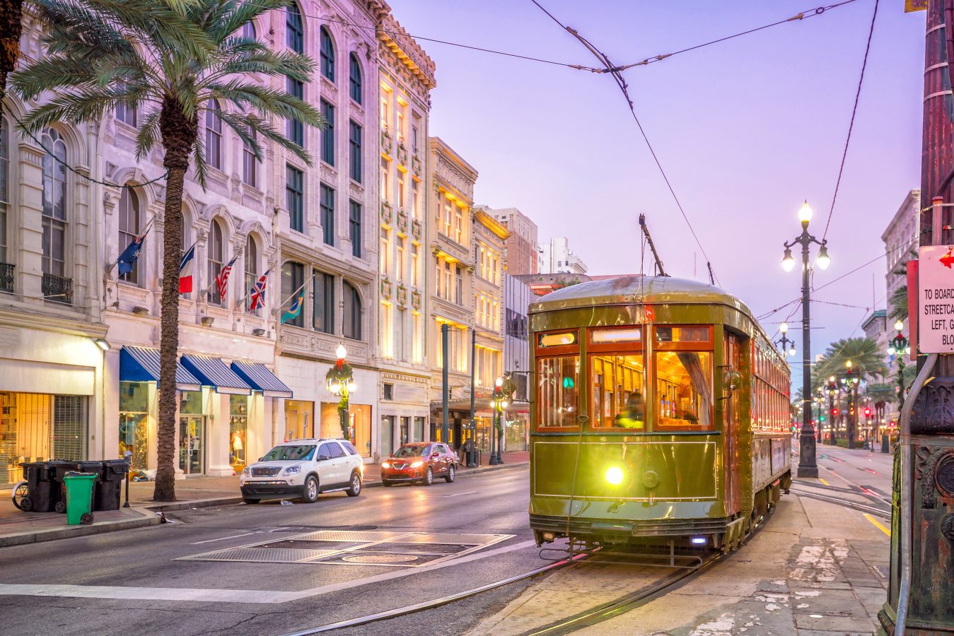 A streetcar going down the street in downtown New Orleans, USA at twilight.