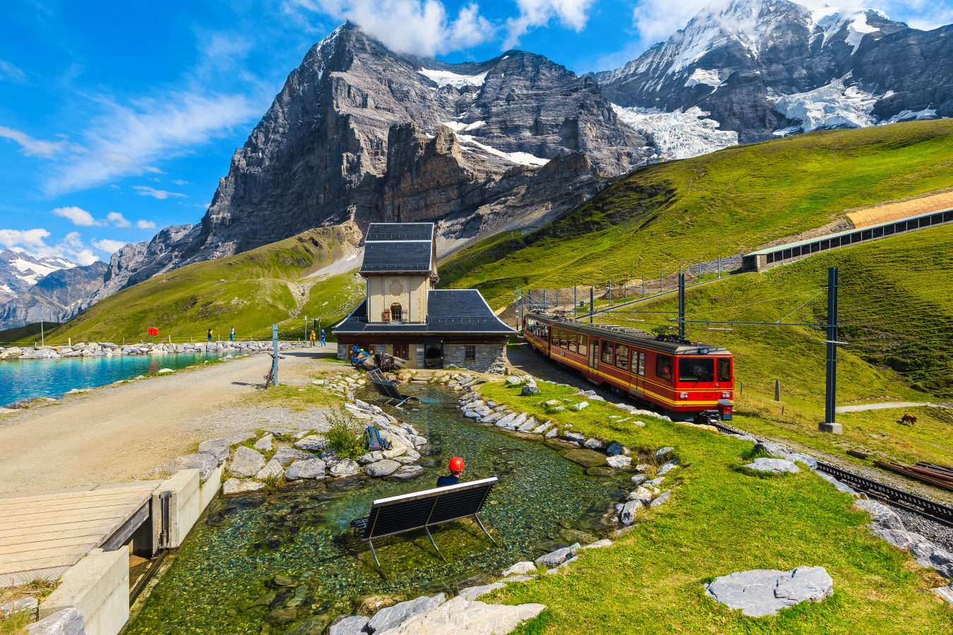 Cogwheel red passenger train in the small mountain station on the shore of the Fallbodensee lake, Jungfraujoch, Bernese Oberland, Switzerland, Europe.