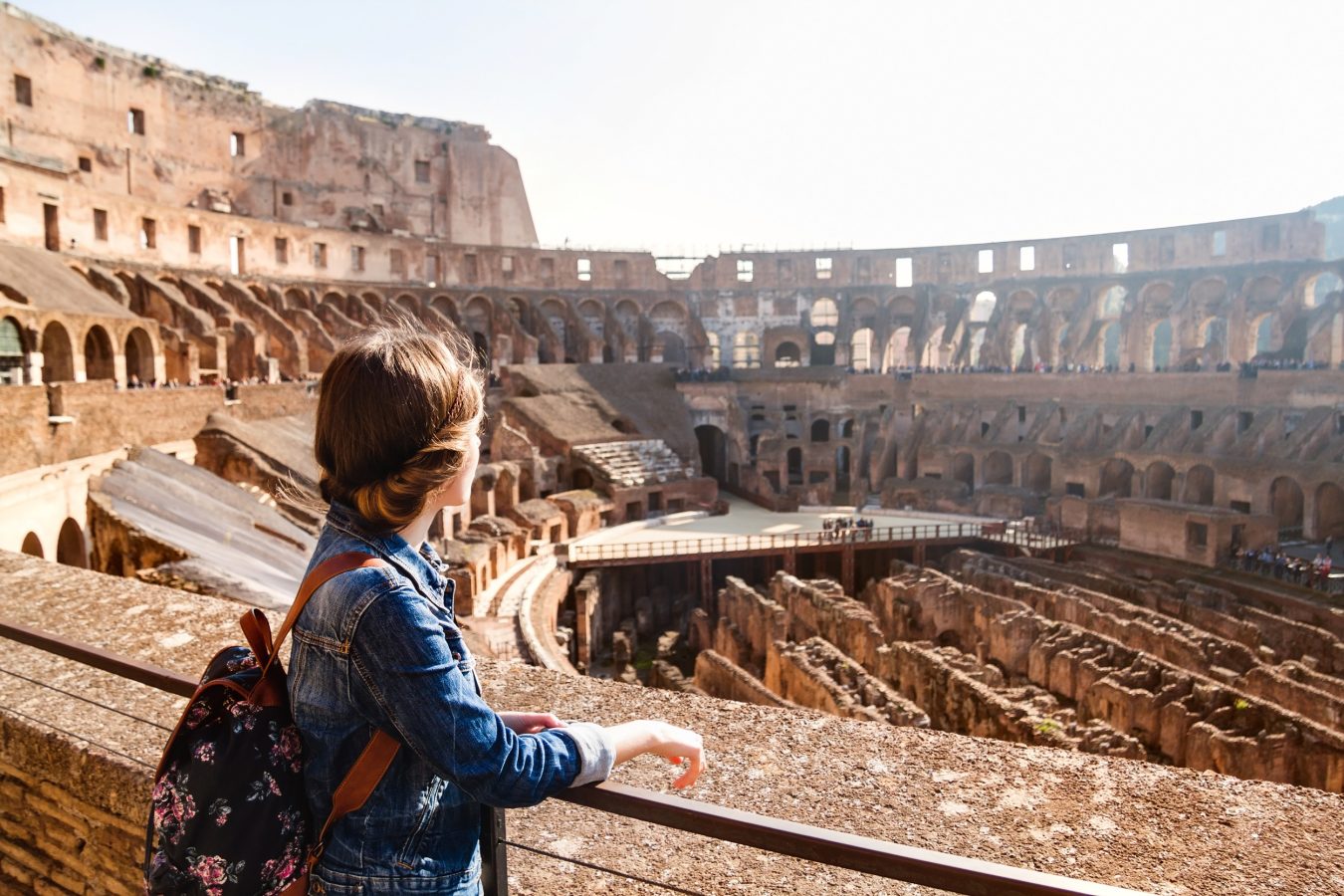 Girl with backpack exploring inside the Colosseum (Coliseum). Rome, Italy