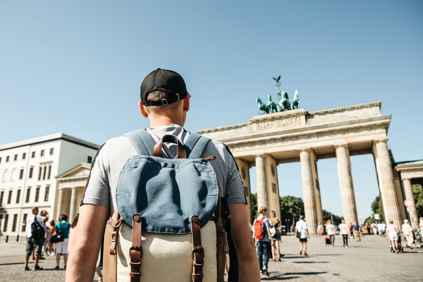 A study abroad student with a backpack in Berlin, Germany visits the Brandenburg Gate.