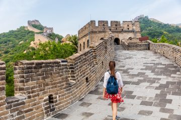 Young adult walking along the Great Wall of Chine during her gap year travel journey.
