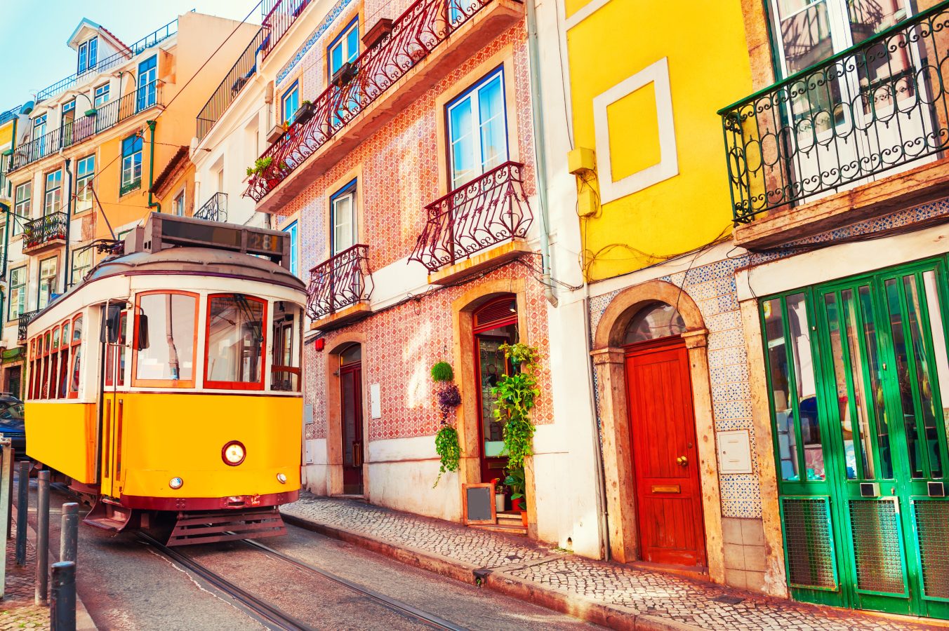 Yellow vintage tram on the street in Lisbon, Portugal. Famous spring break destinations for travel